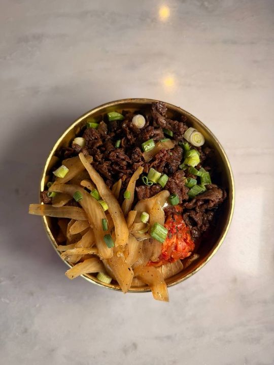 A signature KBBQ steak bowl featuring marinated beef and fresh vegetables served over rice at Chimac Houston.
